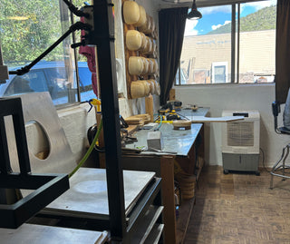 Workshop or studio with tools, materials, and equipment on tables.
